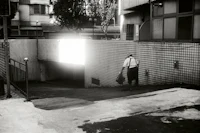 a black and white photo of a man walking down a street