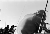 a black and white photo of a group of people fishing