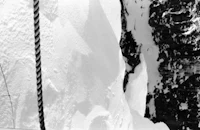 a black and white photo of a skier on a snowy slope